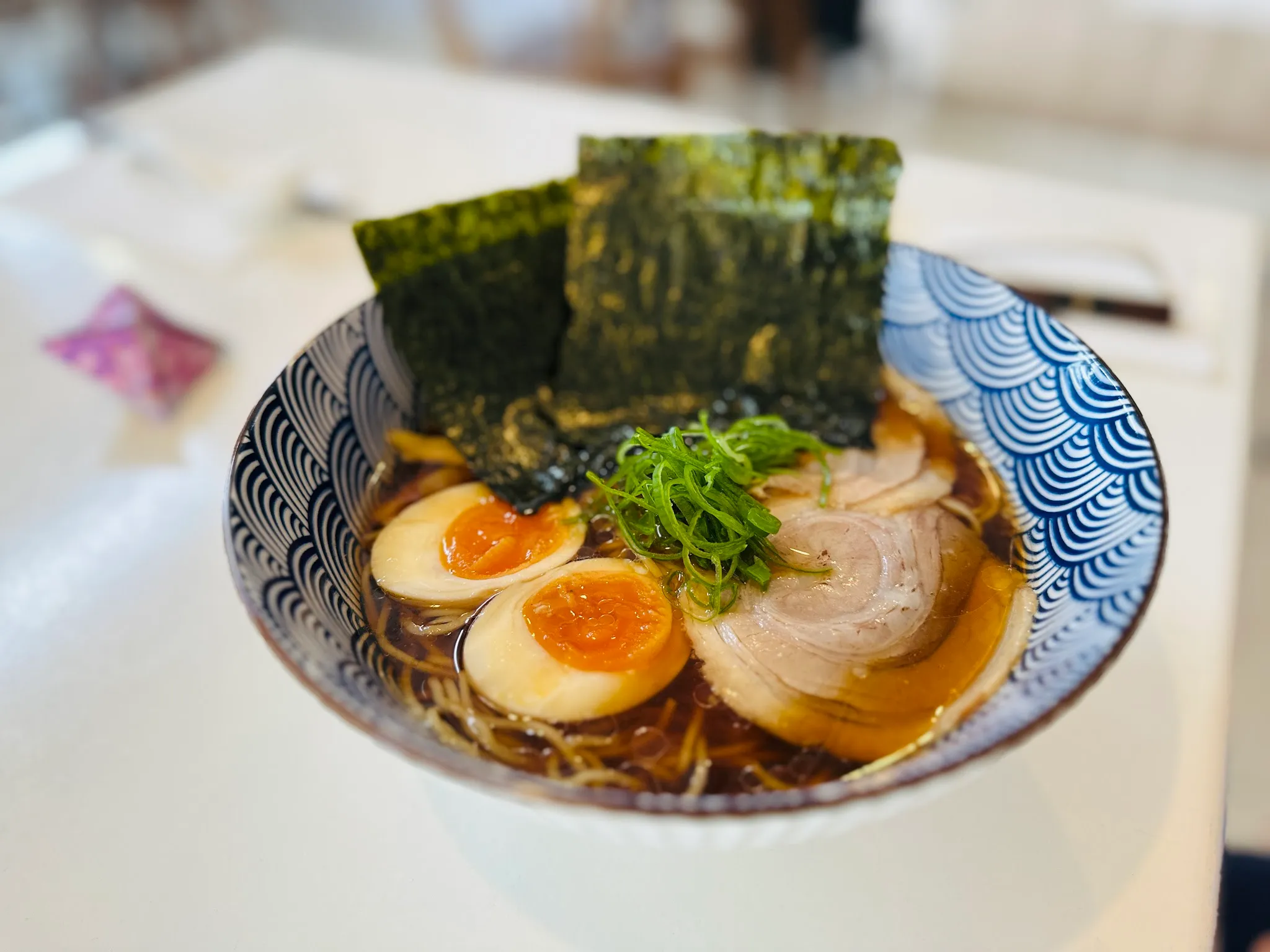 Shoyu ramen in blue seigaiha bowl with golden broth and marinated eggs
