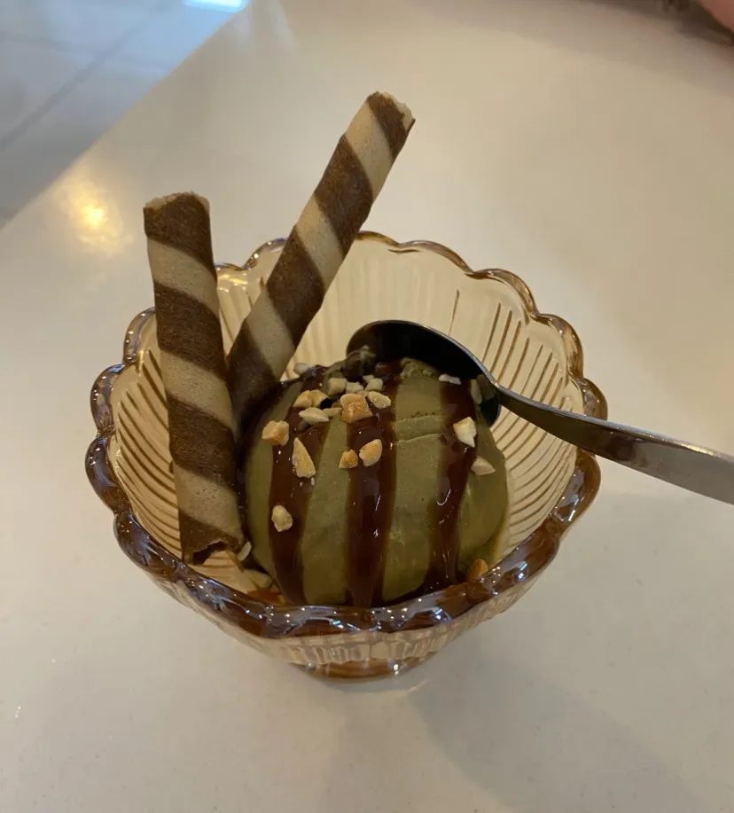 Matcha ice cream in amber glass sundae cup with chocolate drizzle and wafers